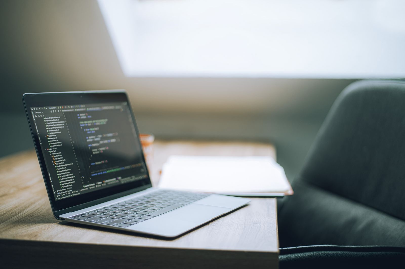 Laptop displaying software code in a modern workspace